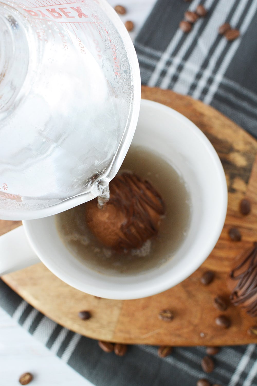Pouring hot water over a coffee bomb in a mug.