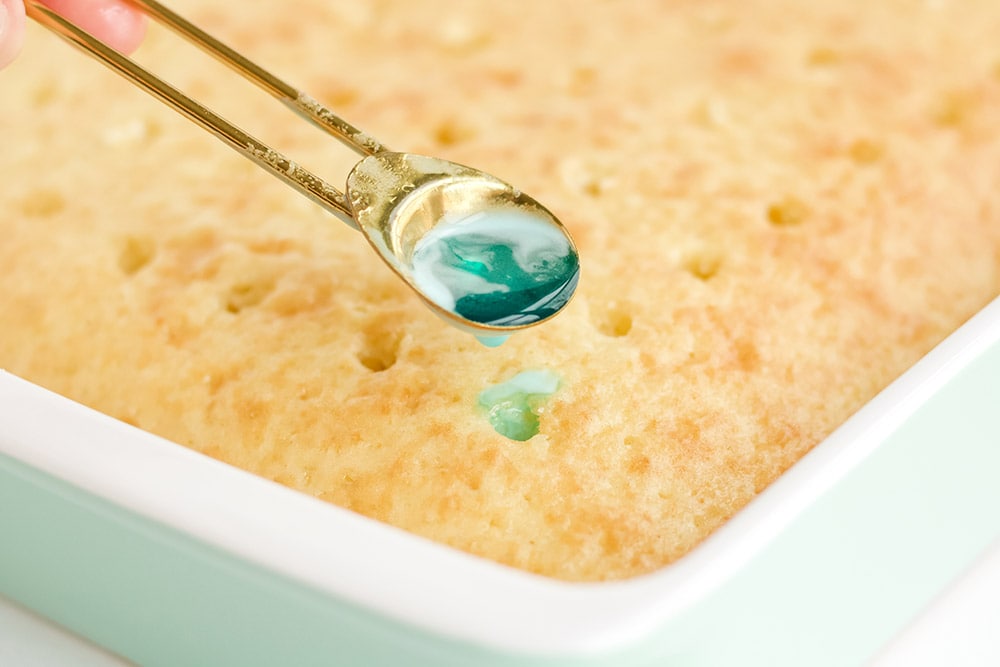Spoonful of jello over a poke cake.