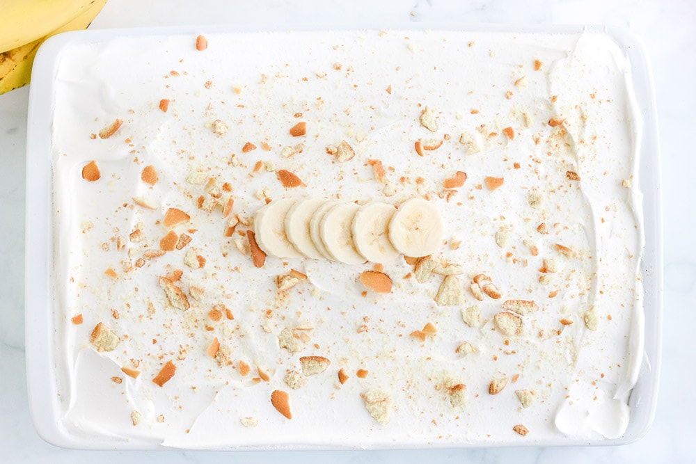 Top of cake topped with white frosting and cookie crumbles.