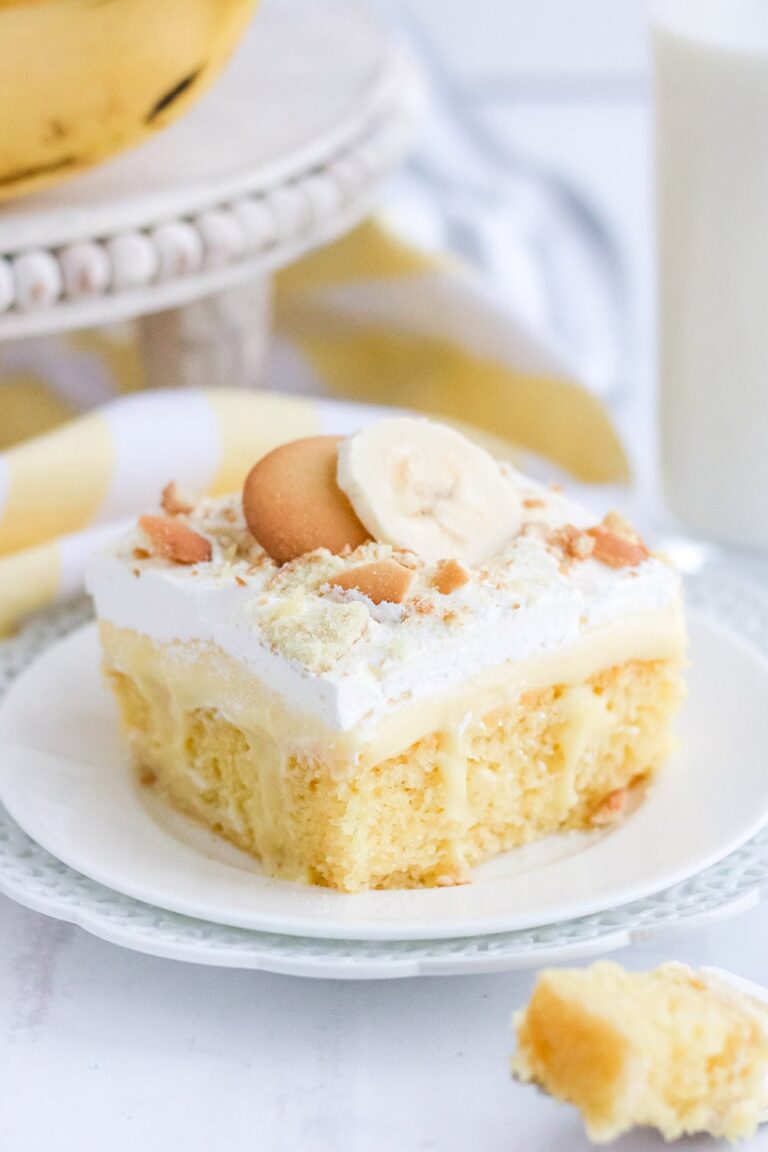 Banana pudding cake topped with whipped cream and cookies.