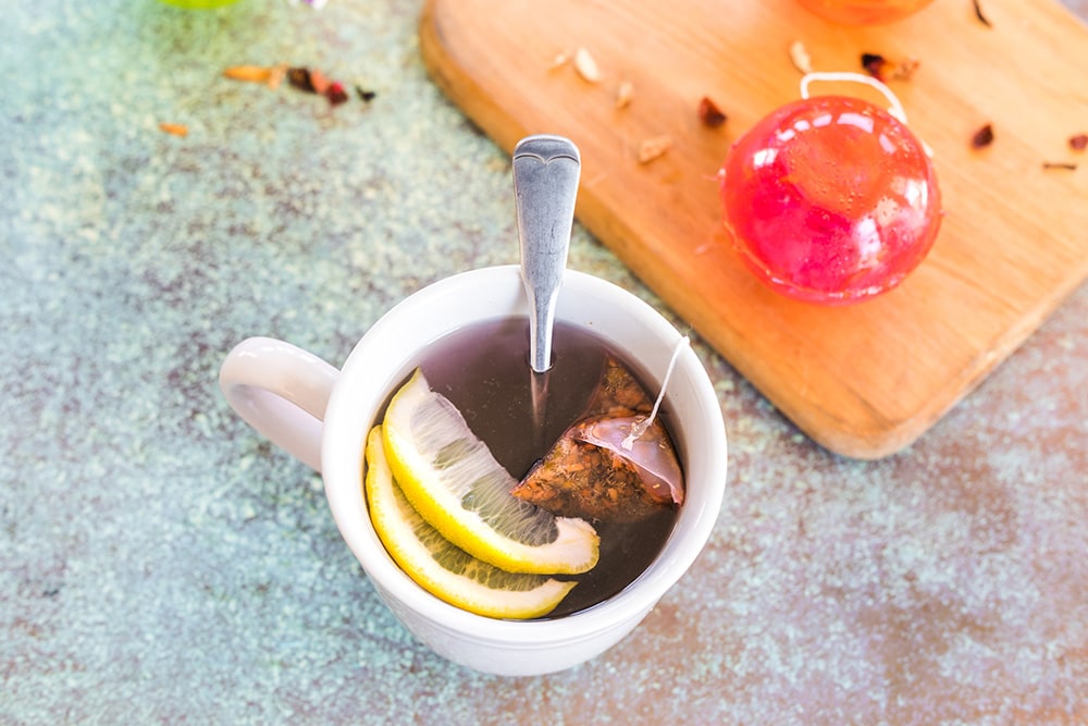 Mug full of tea with a lemon.