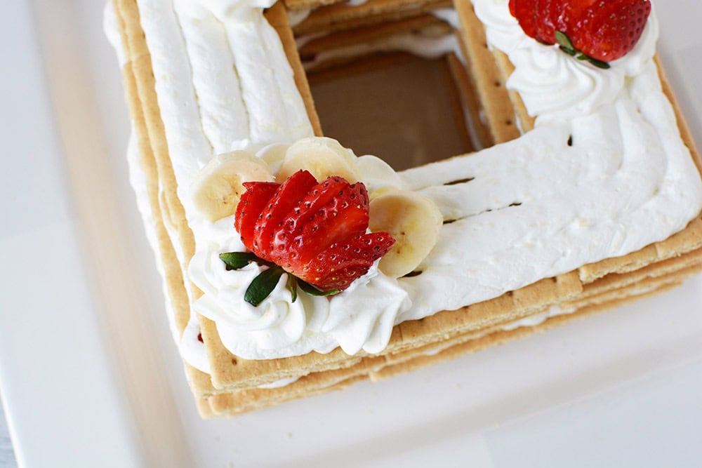 Strawberries and whipped cream on top of graham crackers. 
