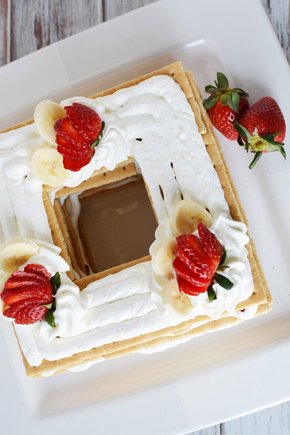 Overhead shot of ice box cake topped with whipped cream and strawberries.