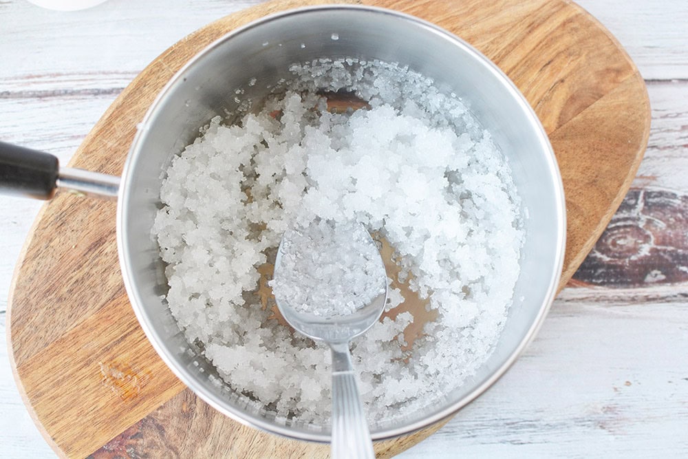 Stirring sugar and water in a sauce pan.