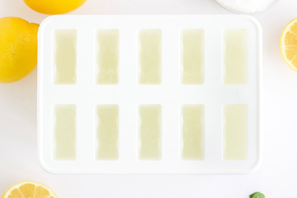 Lemon mixture poured into a white popsicle mold.