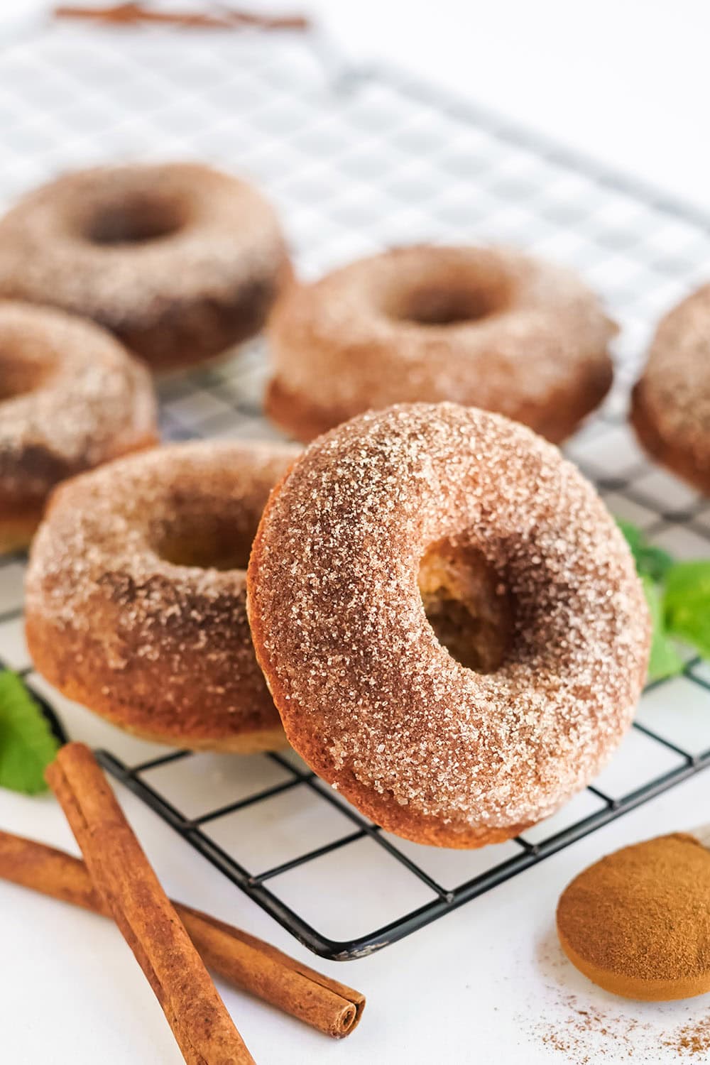 Doughnuts and cinnamon sticks on a rack.