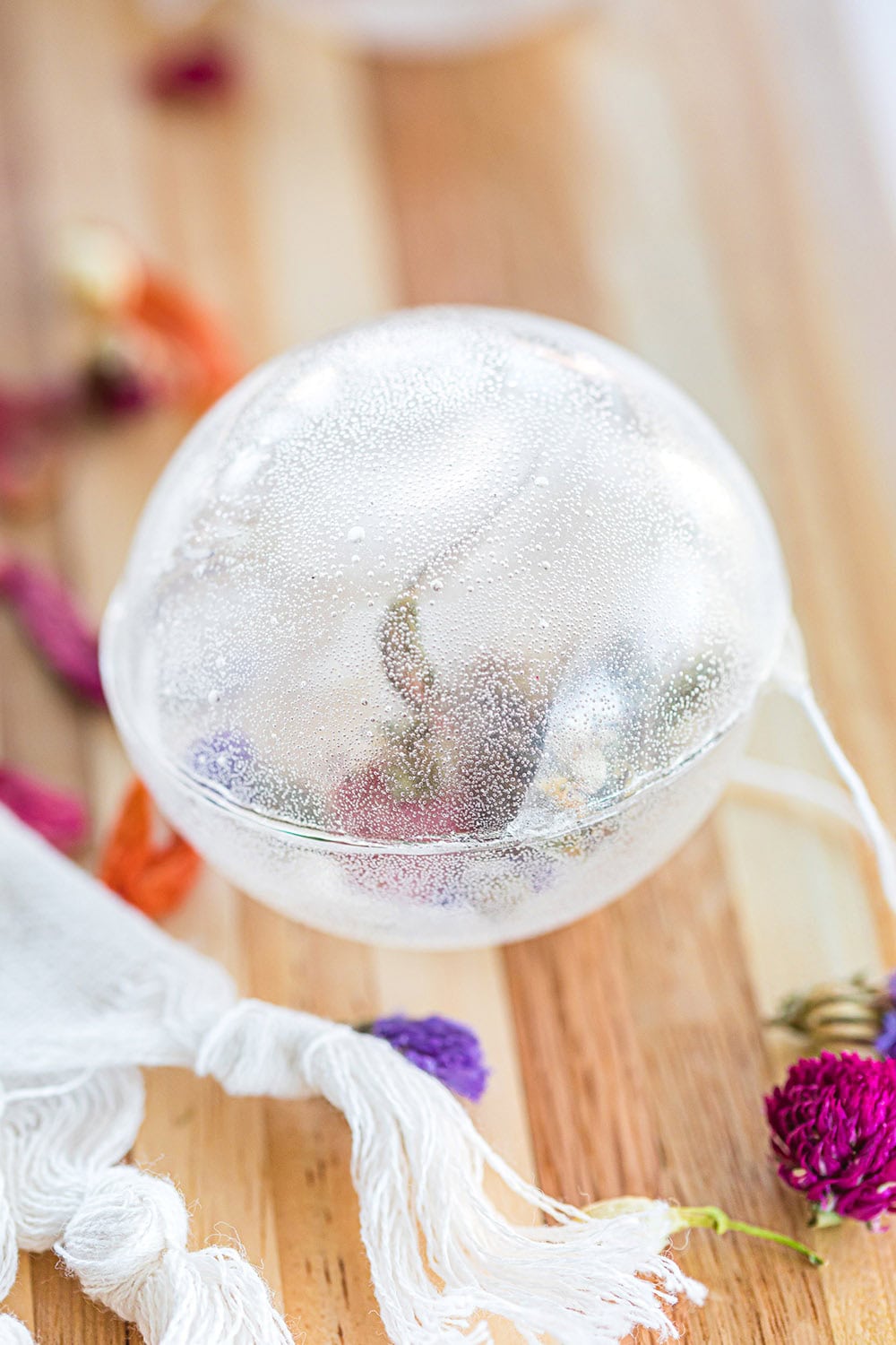 Clear tea orb with a flower in it.