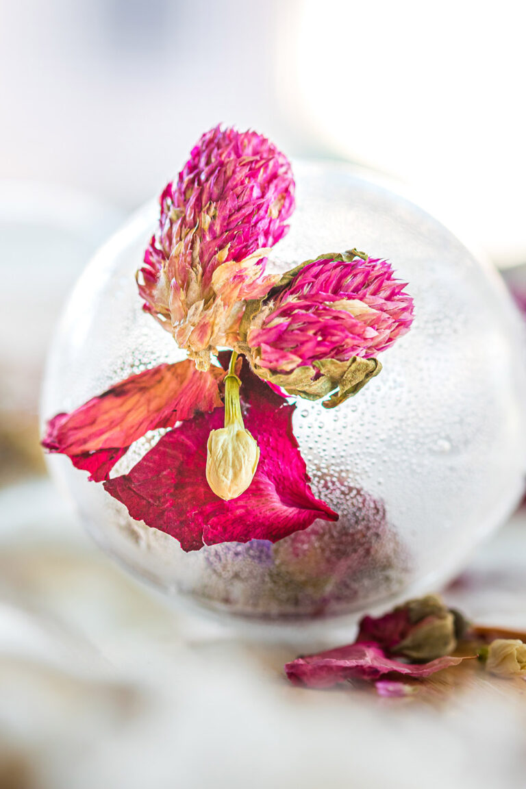 Clear tea globe with a pink flower.