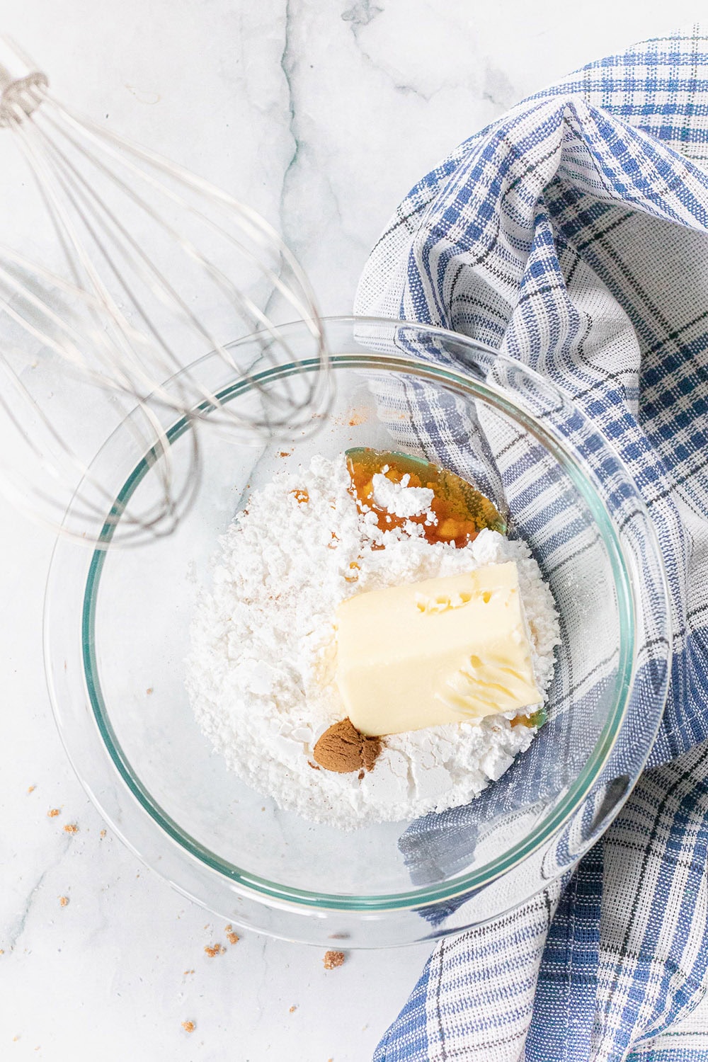 A clear mixing bowl with ingredients in it.