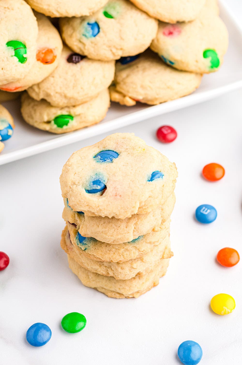 Cookies stacked on top of each other and more on a tray. 