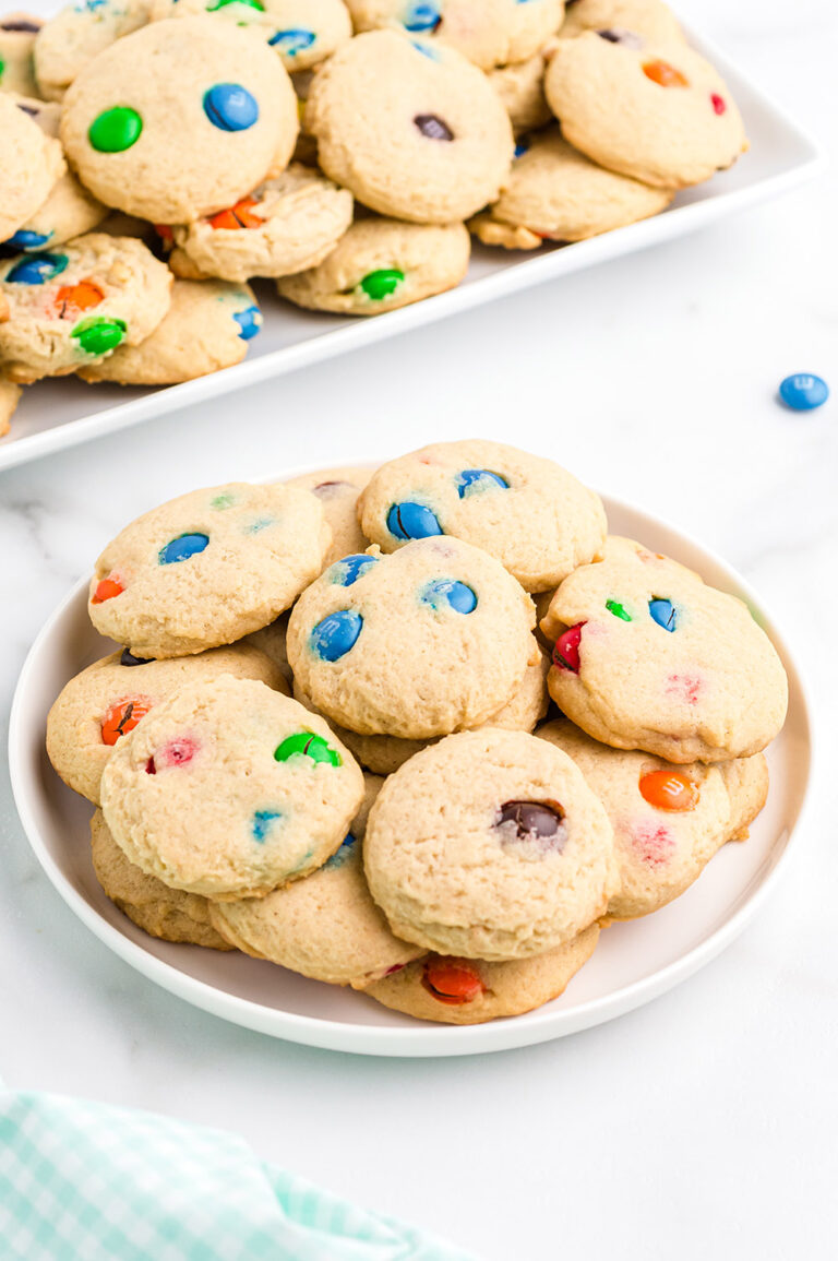 Plate of cookies with more on a tray in the background.