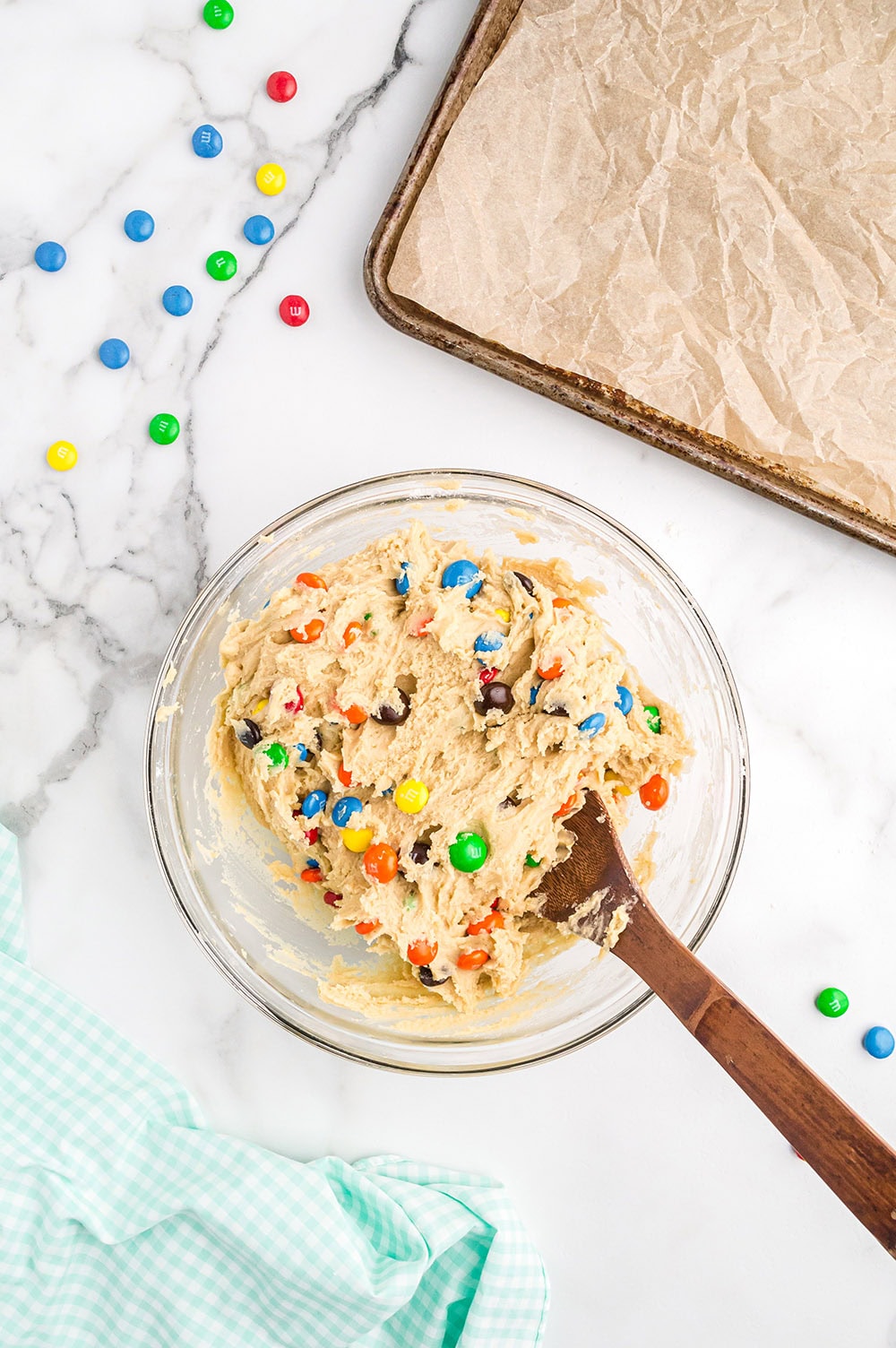 Stirring candies into a mixing bowl with batter.
