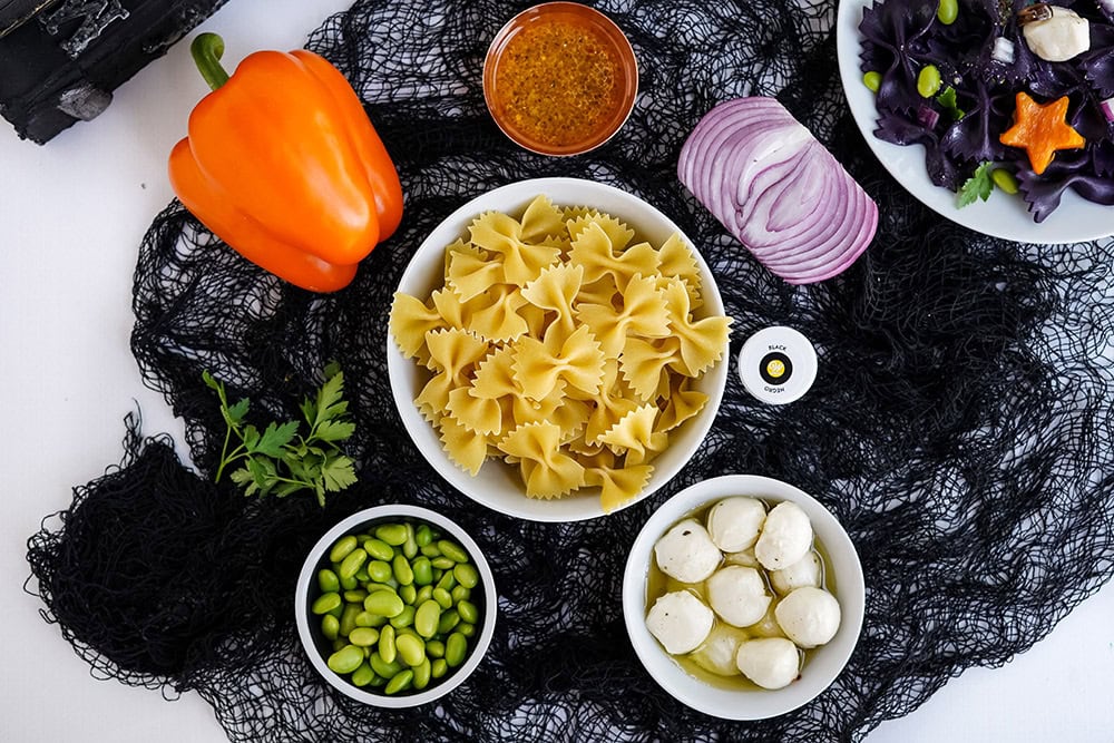 Pasta, pepper, onion, and other ingredients for a halloween pasta salad.
