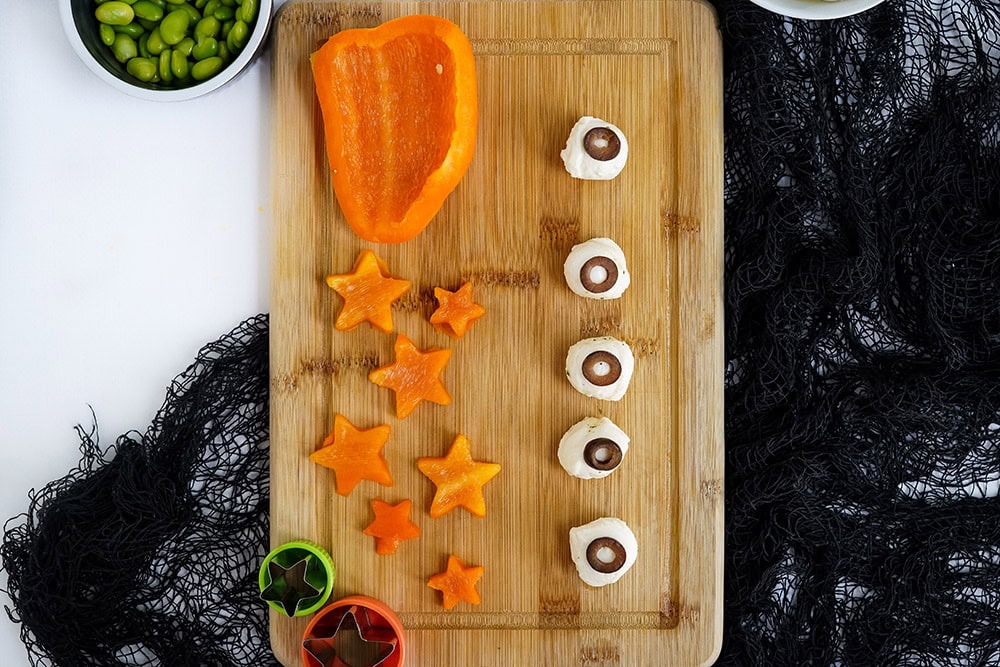 Cut peppers into star shapes and making mozzarella balls that look like eyeballs with olives.