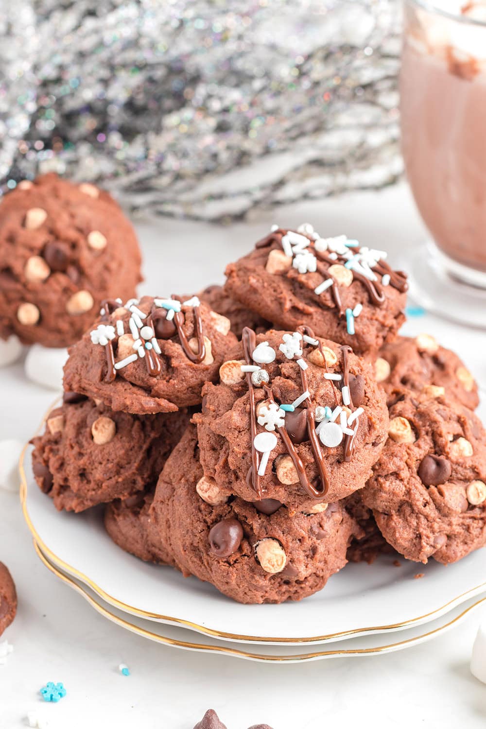 Cocoa cookies stacked ona white plate with holiday decor on table. 