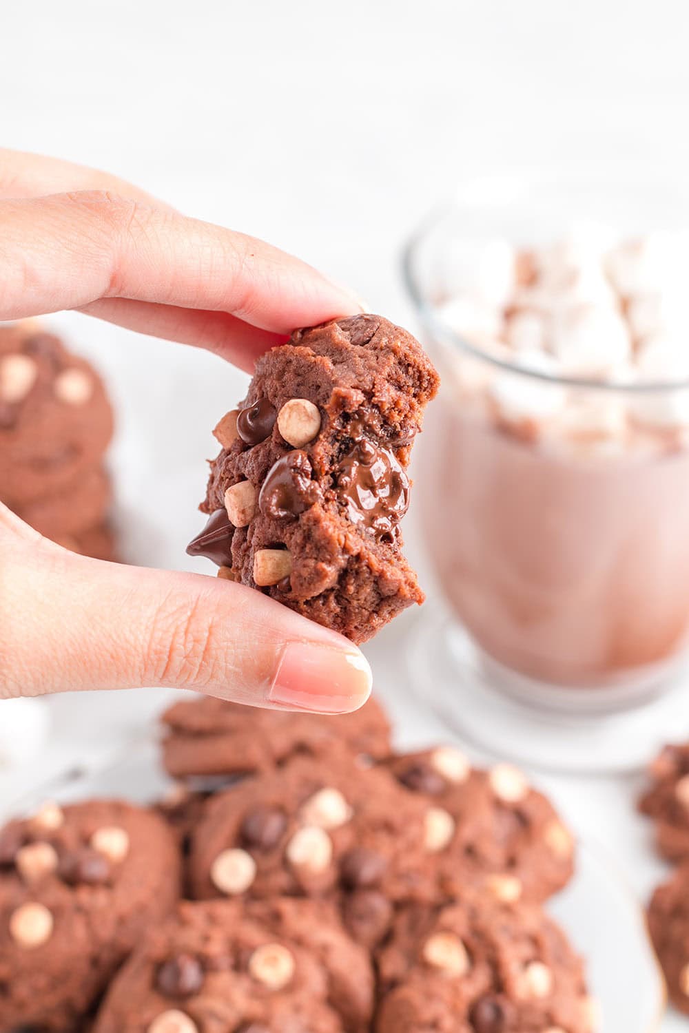 Holding a cookie to show melted chocolate center. 