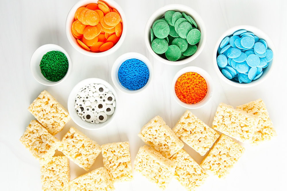 Rice krispie treats, candy melts, and candy eyes on a table. 