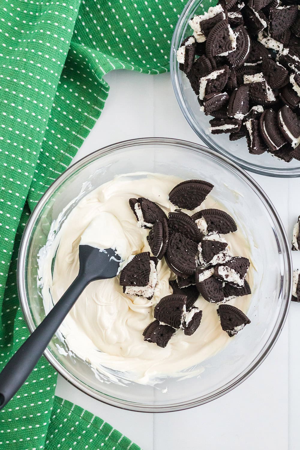 Stirring pieces of OREO cookies into melted white chocolate.