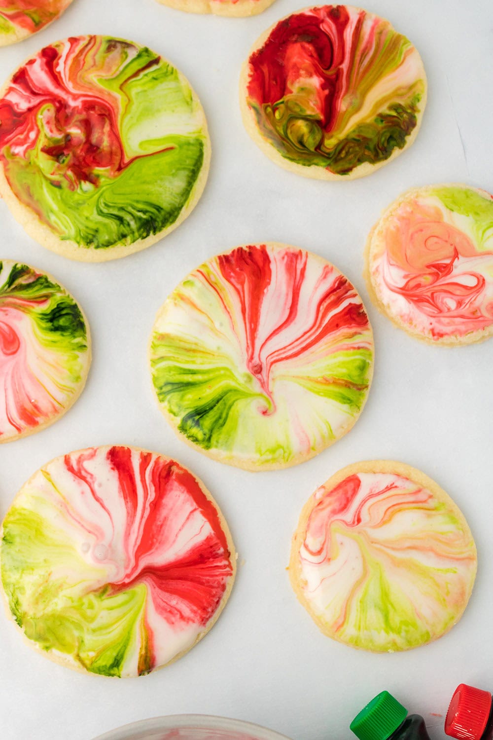 Red and green iced sugar cookies on a sheet. 