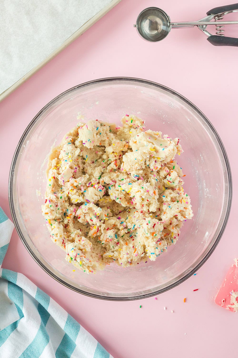 Sprinkles mixed in cookie dough in a bowl.