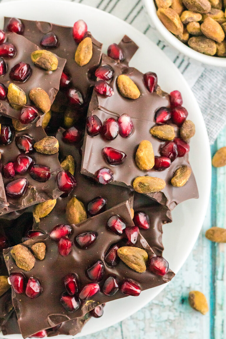 Dark chocolate candy with pistachios and pomegranate arils in it.