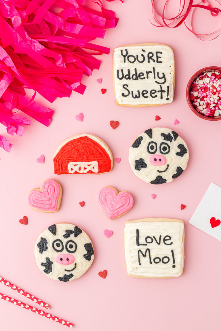 Decorated Valentine cow cookies on a table.