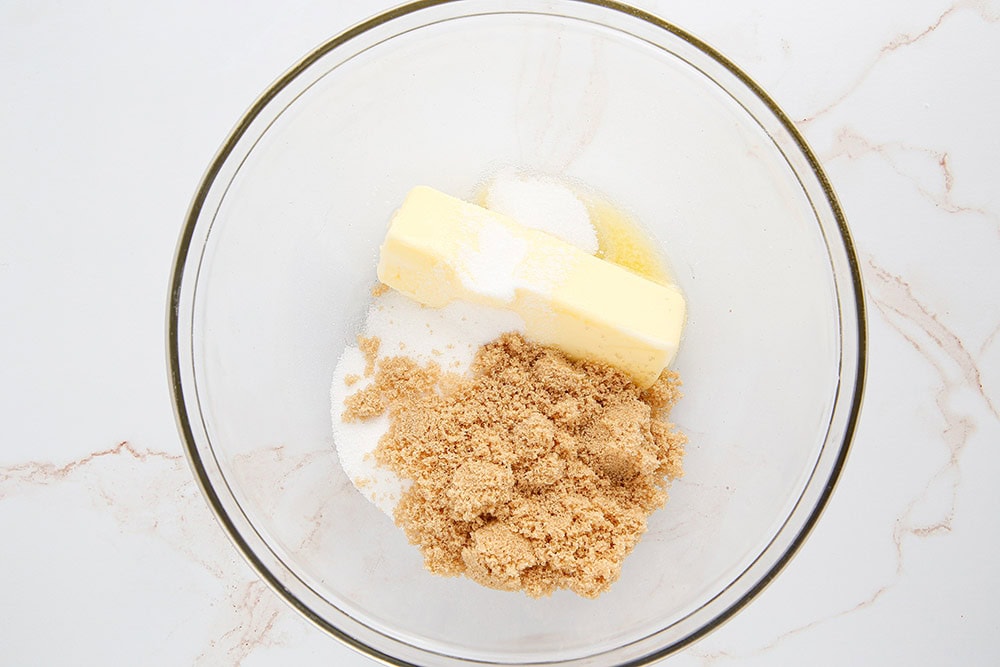 Butter and sugar in a clear mixing bowl. 