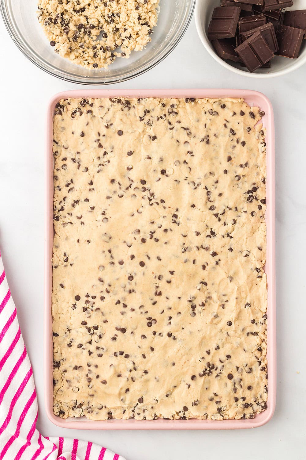 Cookie dough spread onto a baking sheet.