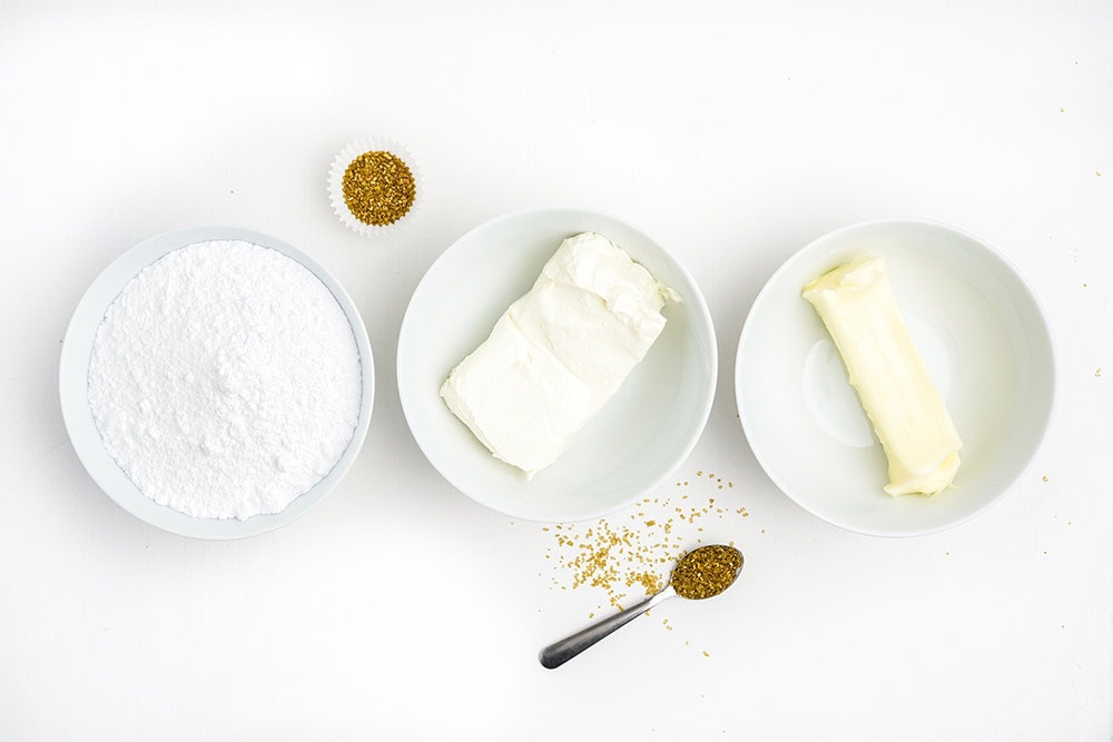 Butter, cream cheese, and other frosting ingredients in bowls. 