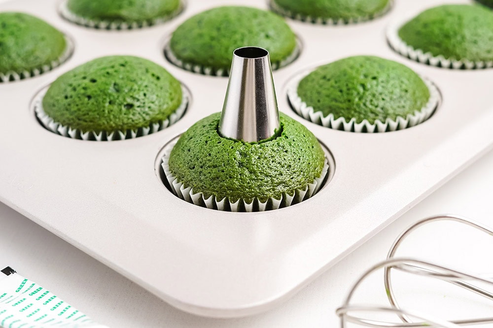 Poking a hole in cupcakes for a surprise filling.