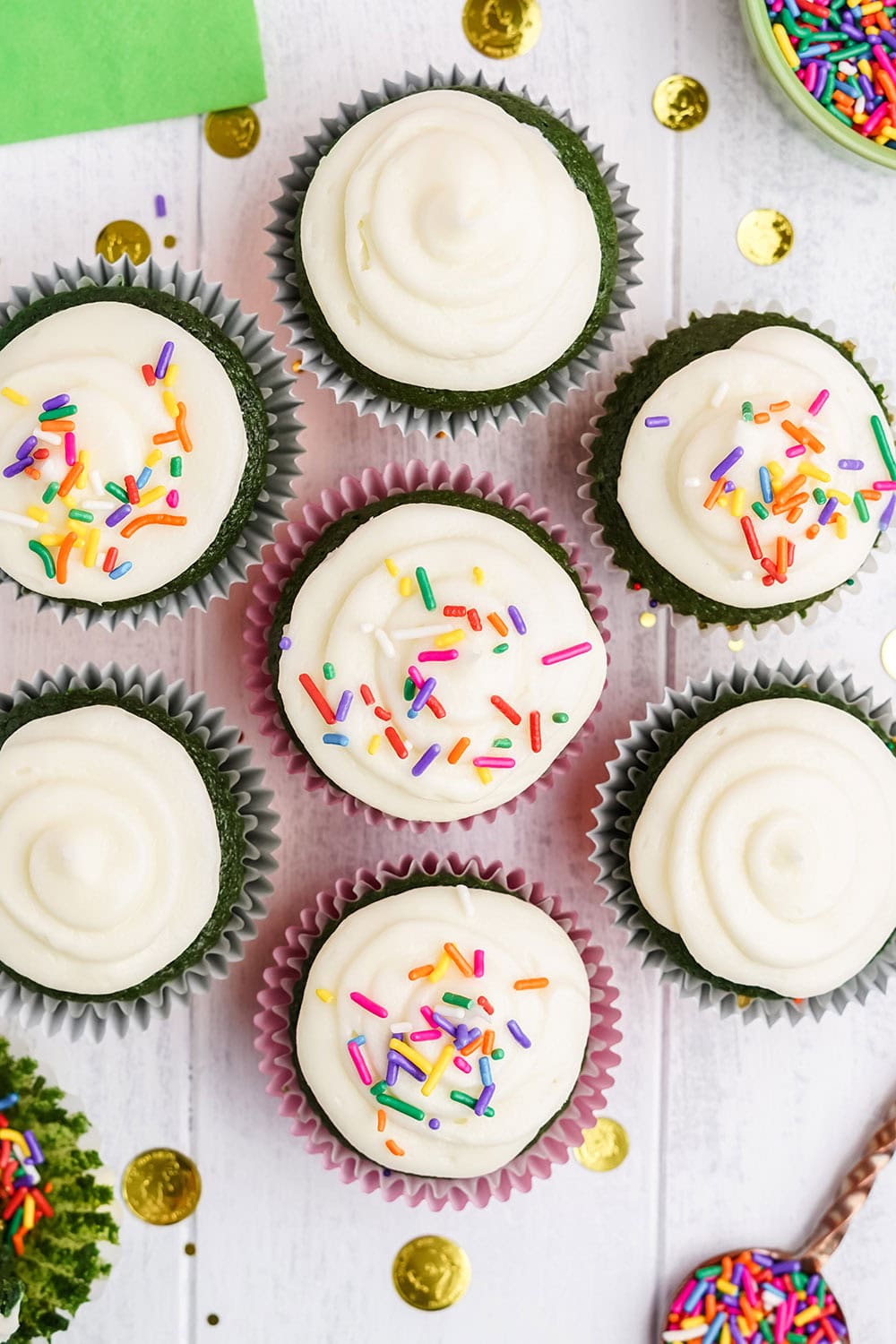 Overhead image of green velvet cupcakes topped with sprinkles. 