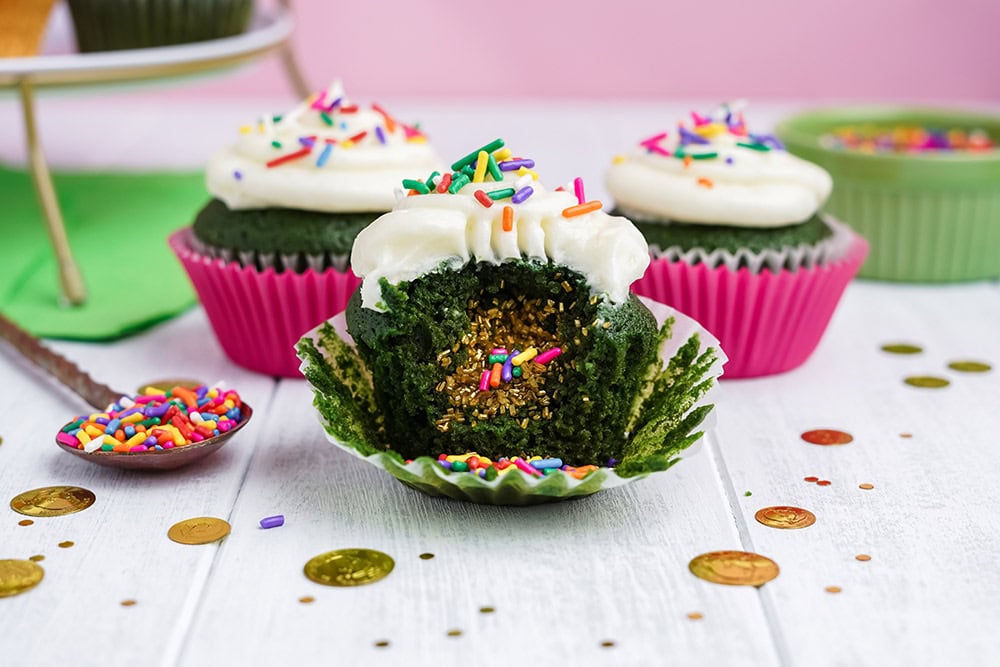 Three green cupcakes with one showing the surprise filling. 