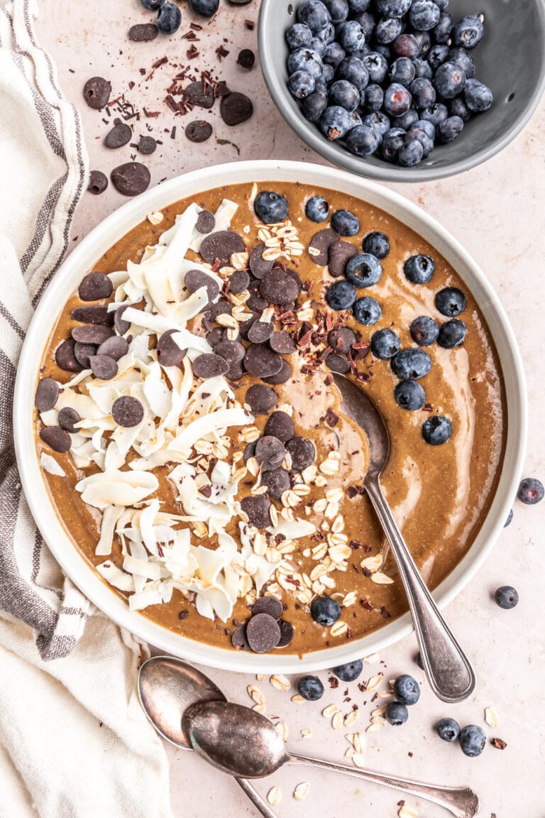 Peppermint mocha smoothie bowl next to a bowl of blueberries.