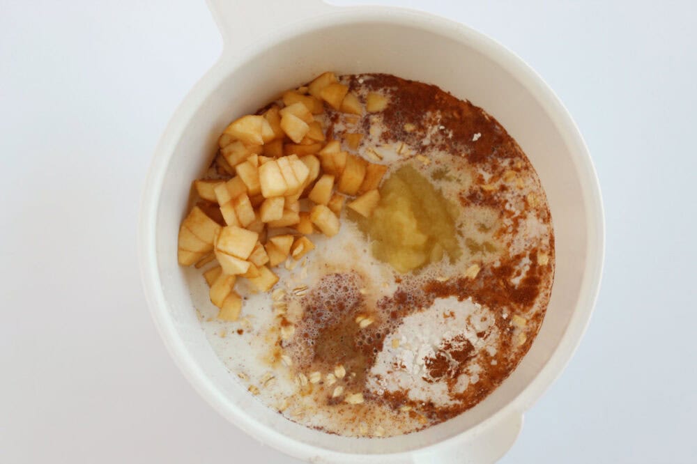 Apples and spices in a mixing bowl.