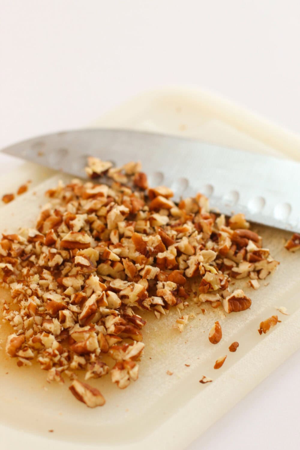 Chopped pecans next to a knife.