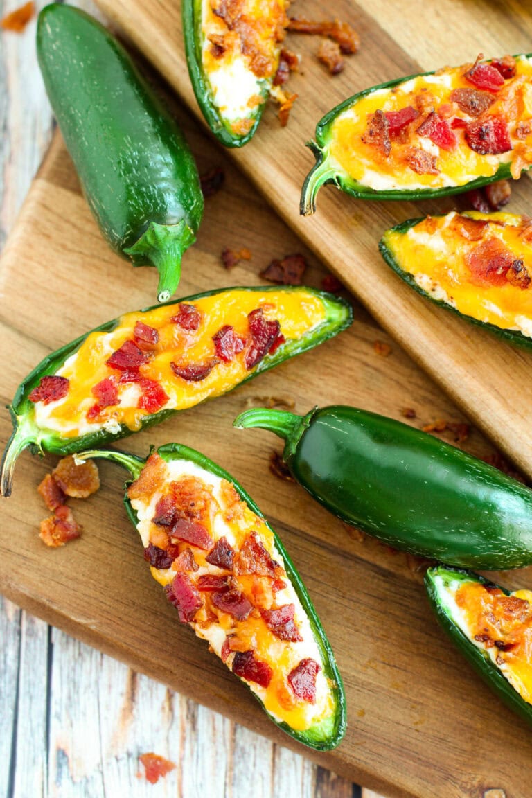 Bacon jalepeno poppers with cream cheese on a surface.