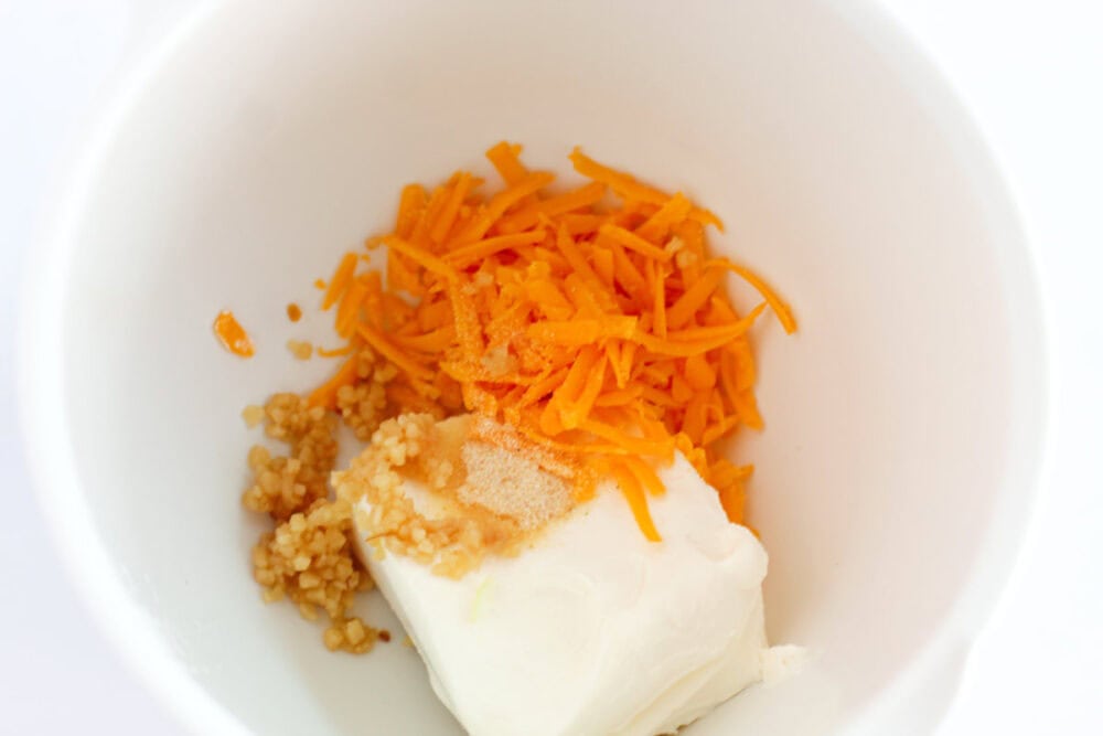 Mixing cream cheese and cheddar in a bowl. 
