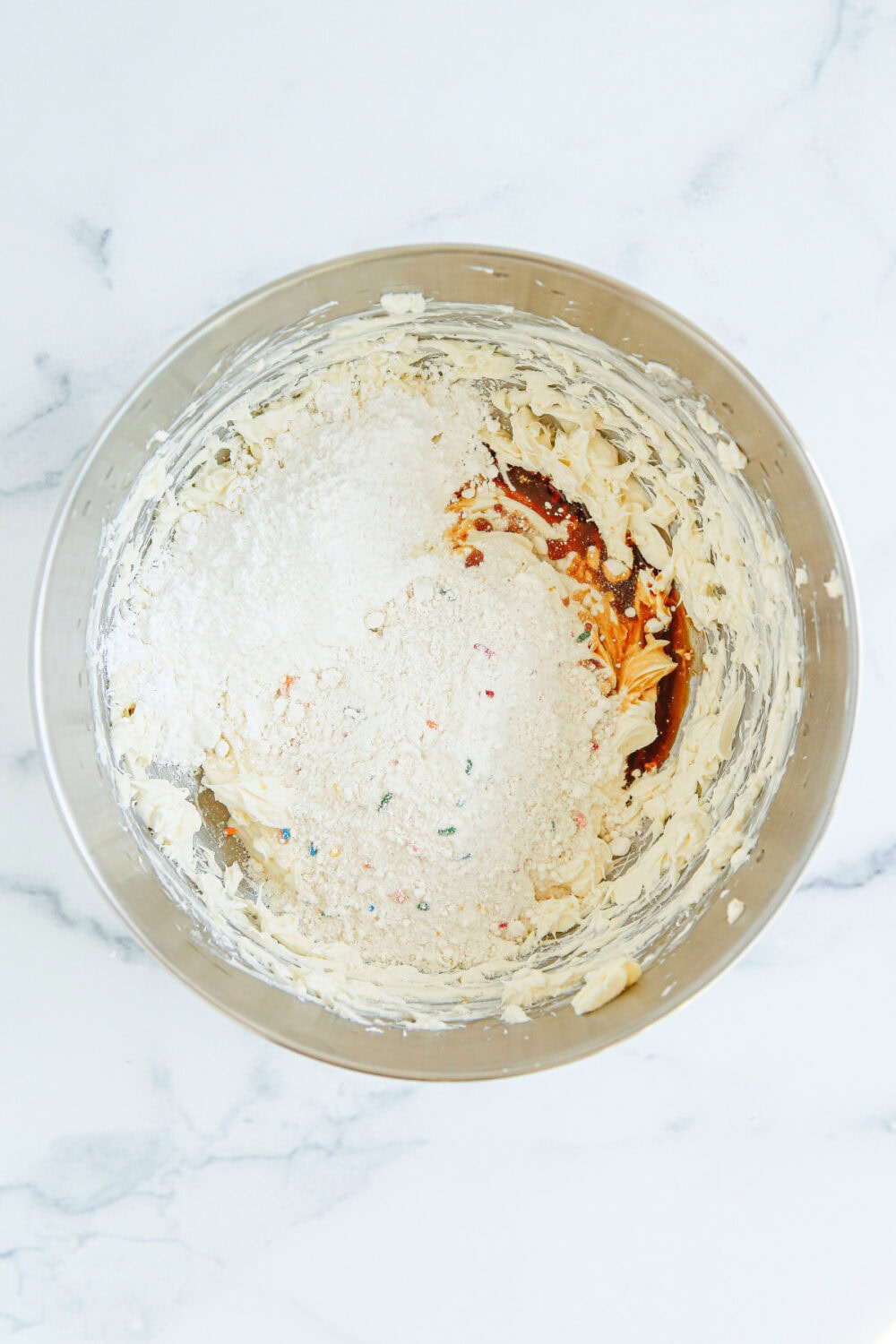 Cream cheese, vanilla, and powdered sugar in a mixing bowl. 