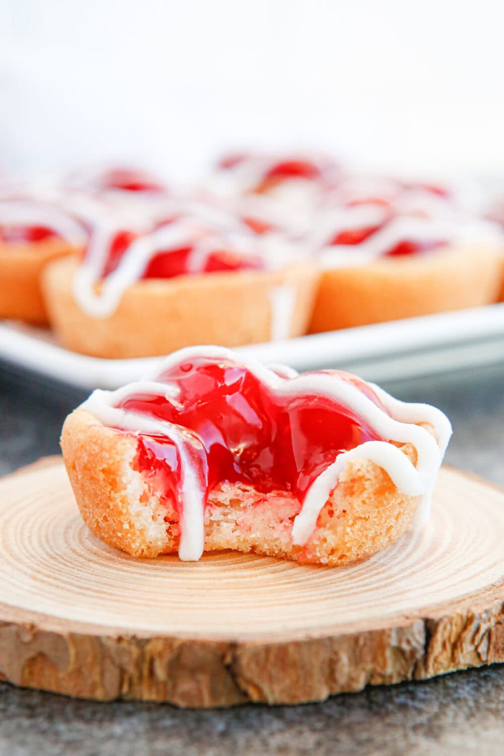 Cherry pie cookies on a board with a bite missing. 
