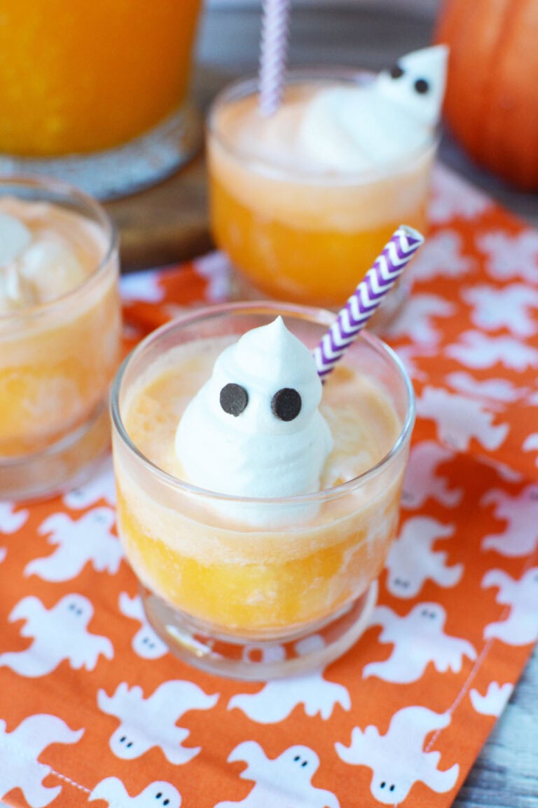 A whipped cream ghost on top of orange punch with ice cream.