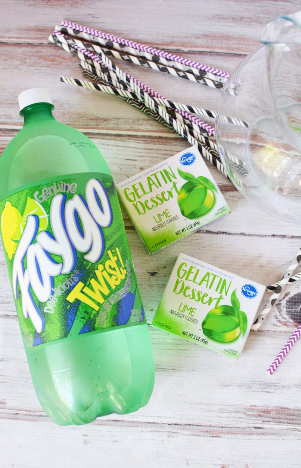 Faygo lemon lime drink, boxes of lime Jello and straws on a table. 