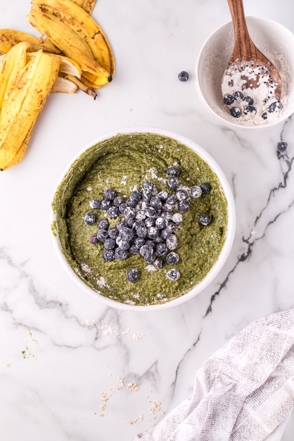 Blueberries on top of spinach mixture in a bowl. 
