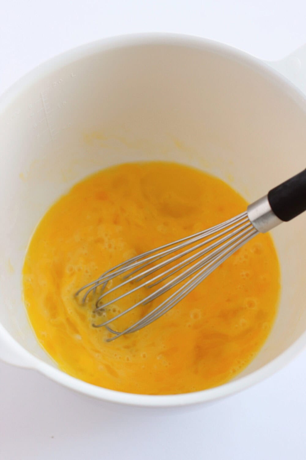 Eggs in a bowl with a whisk. 