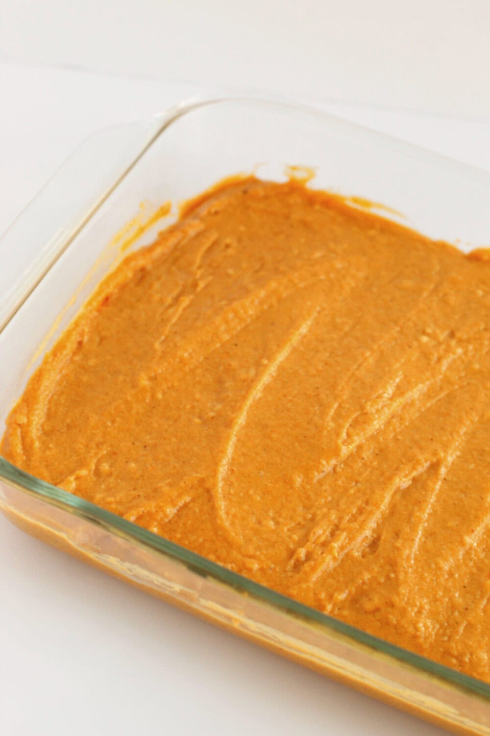 Cake batter in a clear baking dish. 