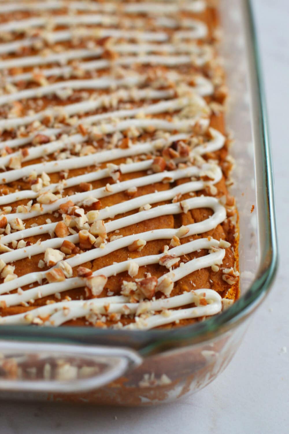 Snack cakes in a baking dish with white chocolate and pecan topping. 