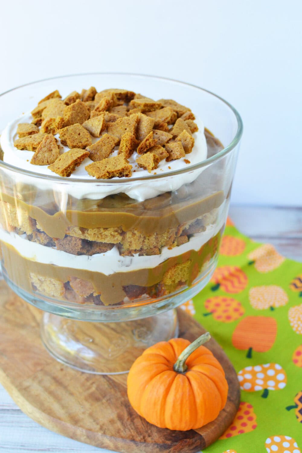 Layers of pumpkin, bread, whipped topping, and cookies in a trifle dessert. 