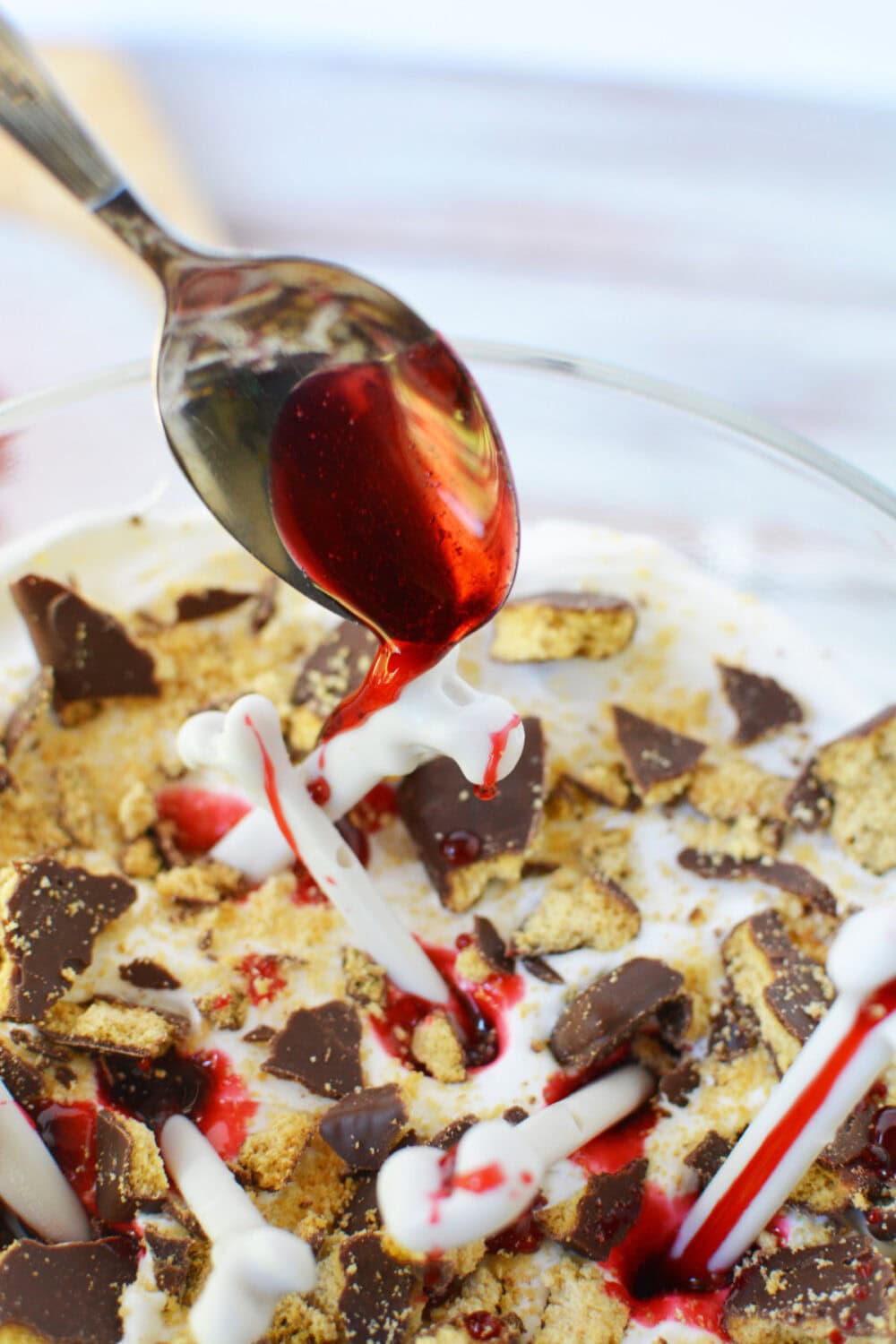 Drizzling red syrup on top of trifle. 
