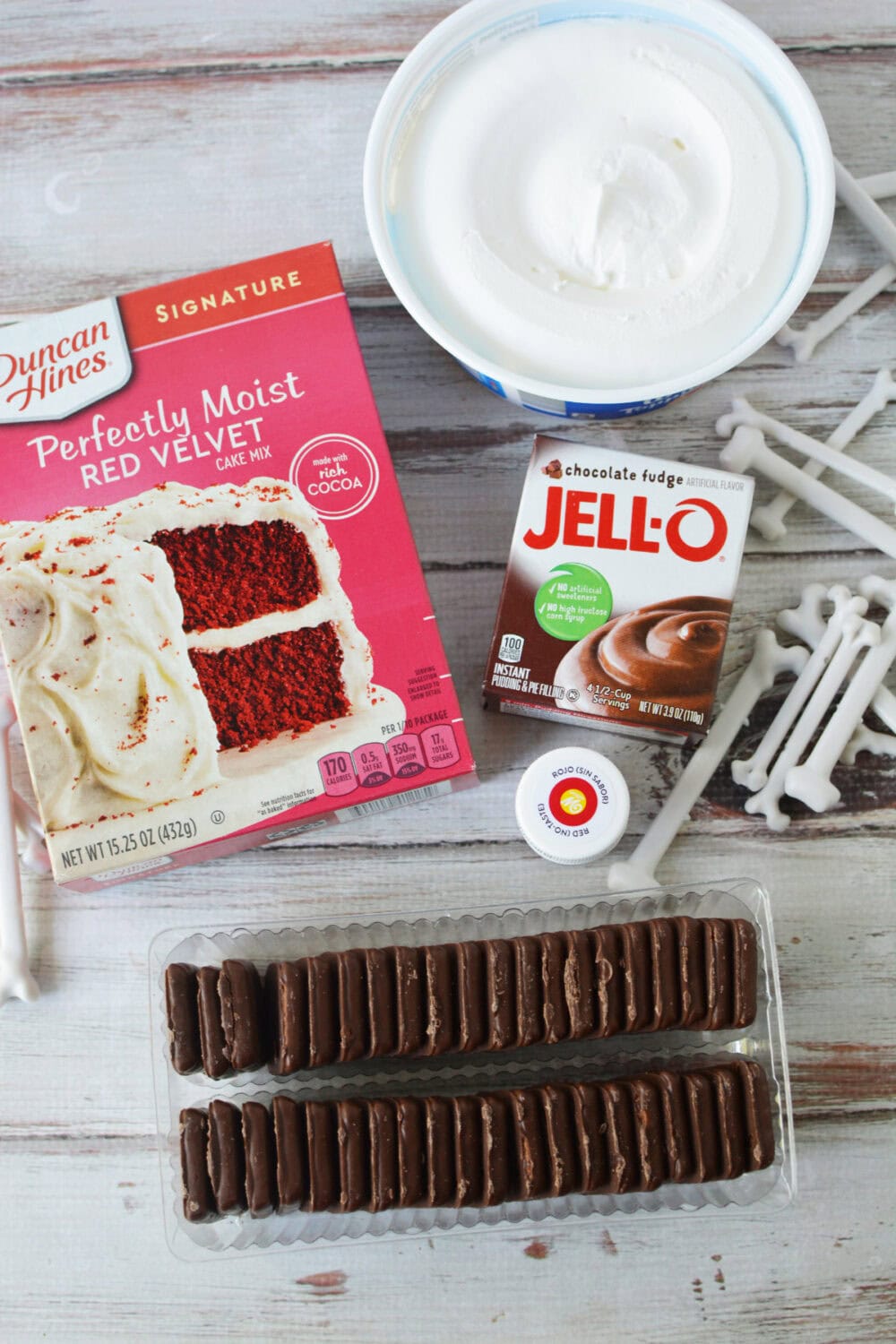 Cake mix, pudding, cookies, whipped topping, and plastic bones on a table. 