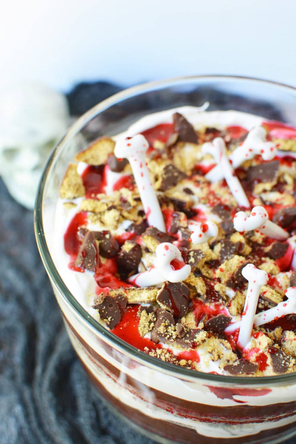 Red velvet trifle topped with bones and cookies pieces. 