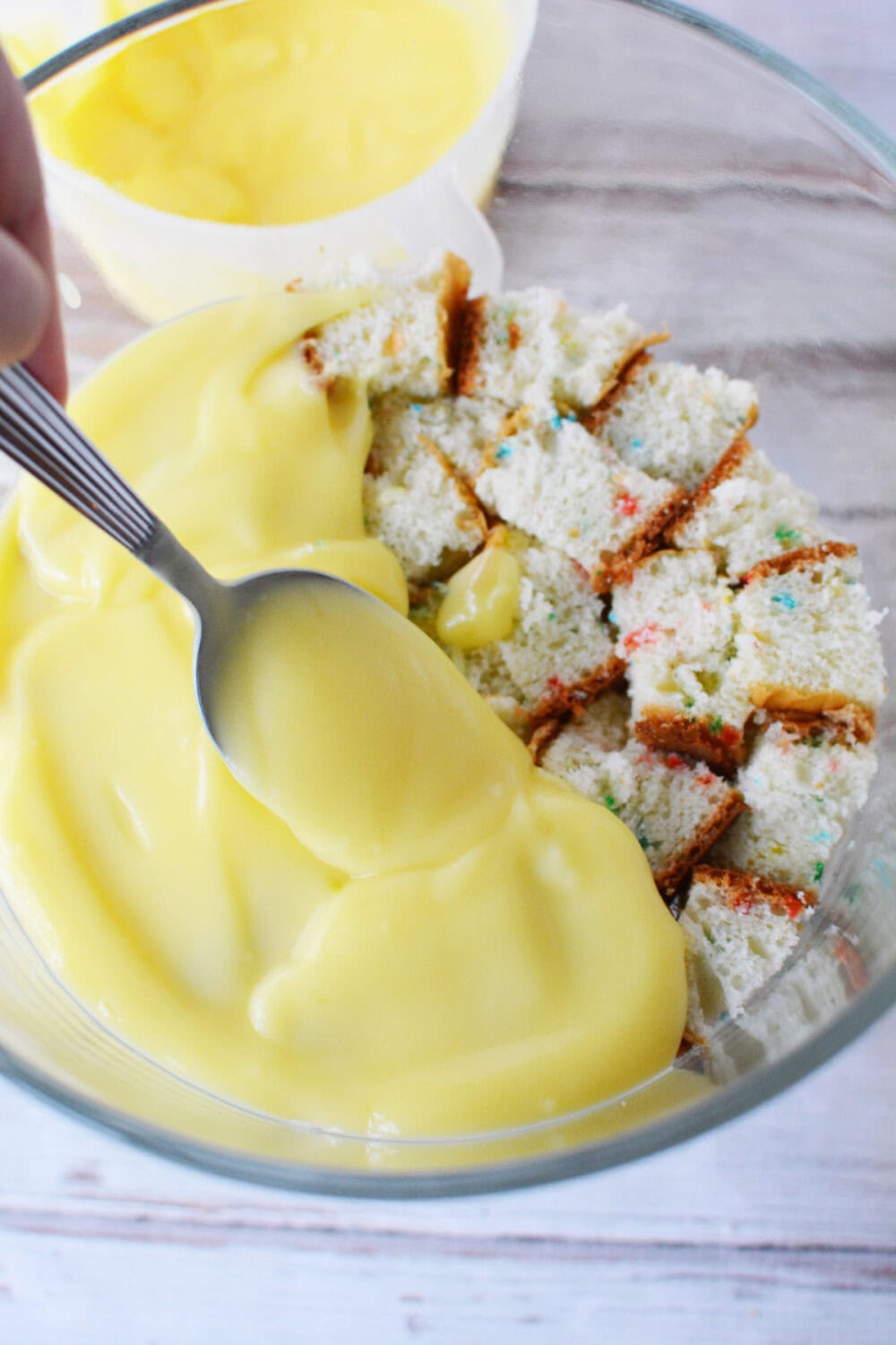 Pudding on top of cake cubes in a trifle bowl. 